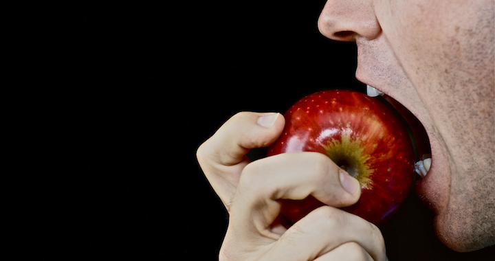 man biting into an apple