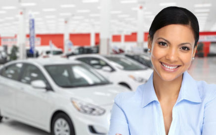 Woman with car dealership showroom in background