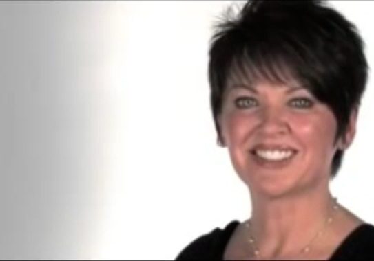 Smiling woman with short, dark hair.