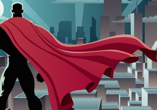 Superhero overlooking cityscape with red cape.